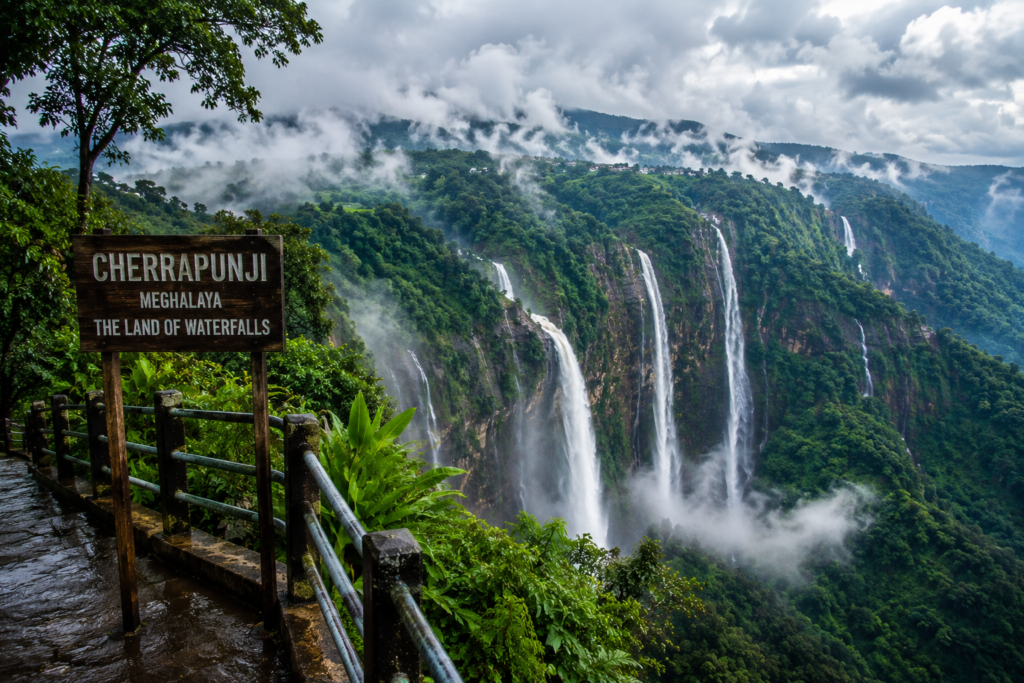 Cherrapunji Meghalaya during monsoon featuring massive waterfalls, misty valleys, lush greenery, and dramatic clouds